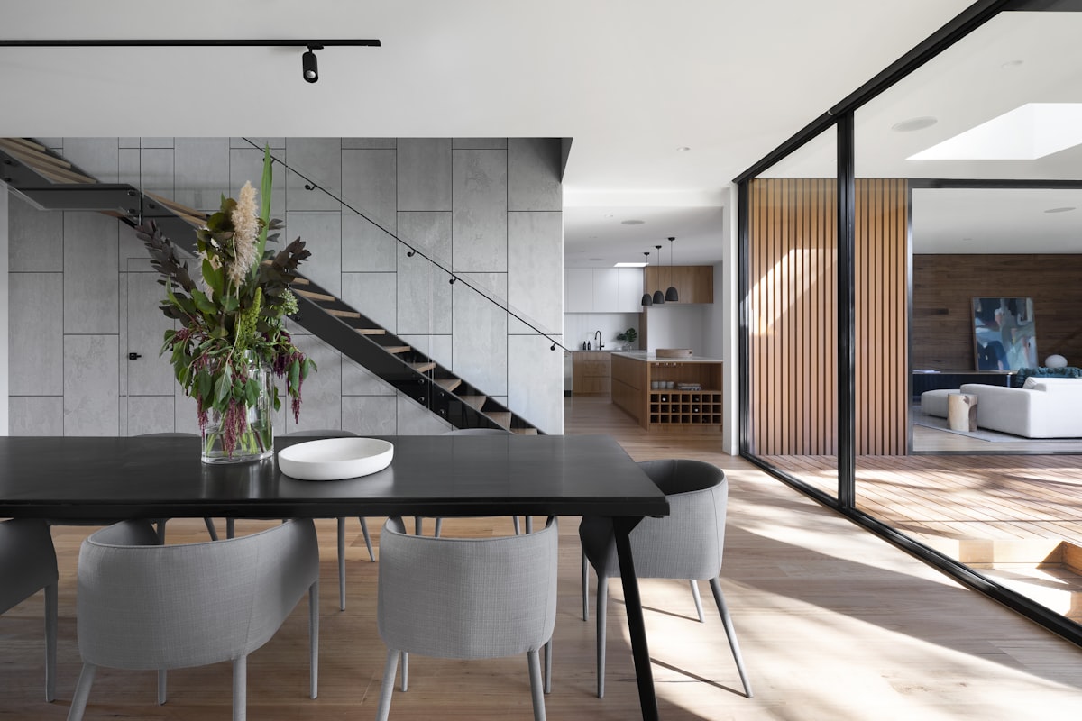 Appartement contemporain à Oran, cuisine ouverte sur salle à manger avec escalier en bois et verrières noires